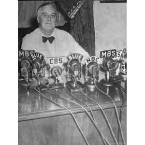 President Franklin D. Roosevelt Sitting Behind a Bank of Microphones 
